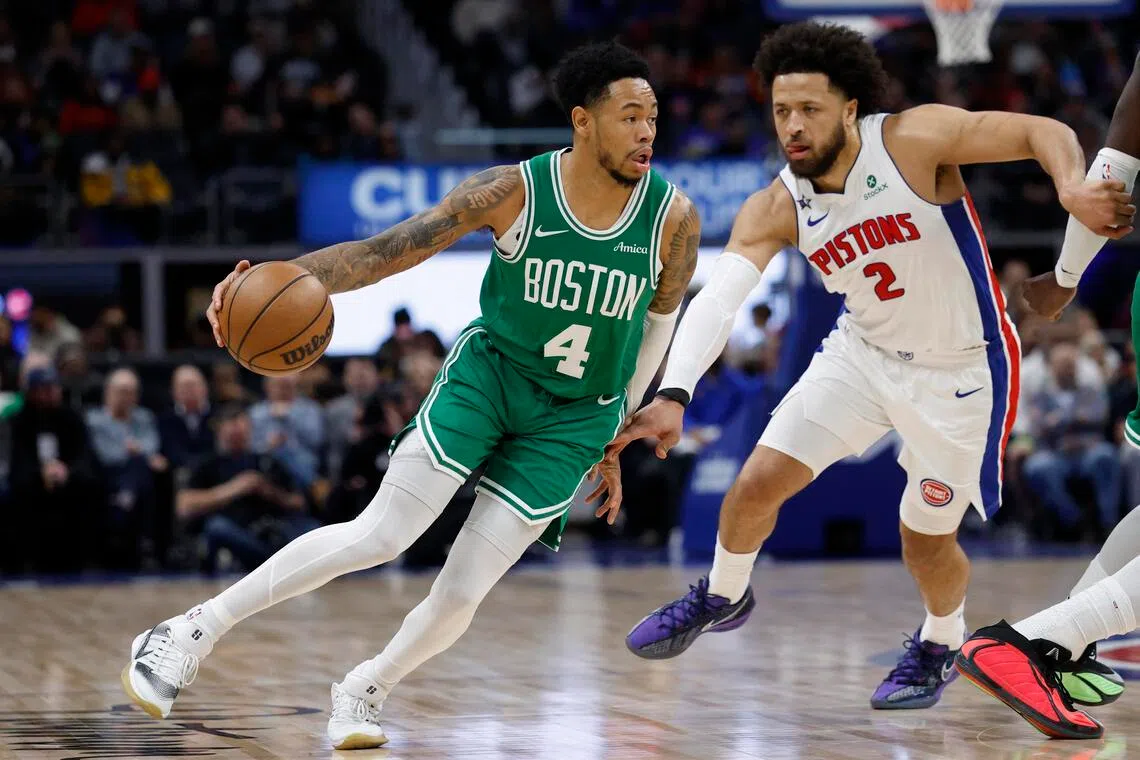 Boston Celtics guard Anfernee Simons dribbles the ball against Detroit Pistons guard Cade Cunningham in the first half at Little Caesars Arena. 