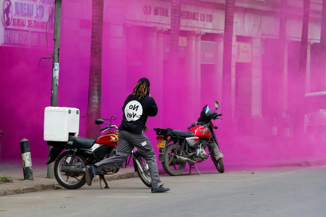 A pro-reform protester reacts to smoke flare during an anti-government demonstration over what organisers say are tax hikes, bad governance, constitutional violations, extra-judicial killings and cost of living, in Nairobi, Kenya, August 8, 2024. REUTERS/Thomas Mukoya