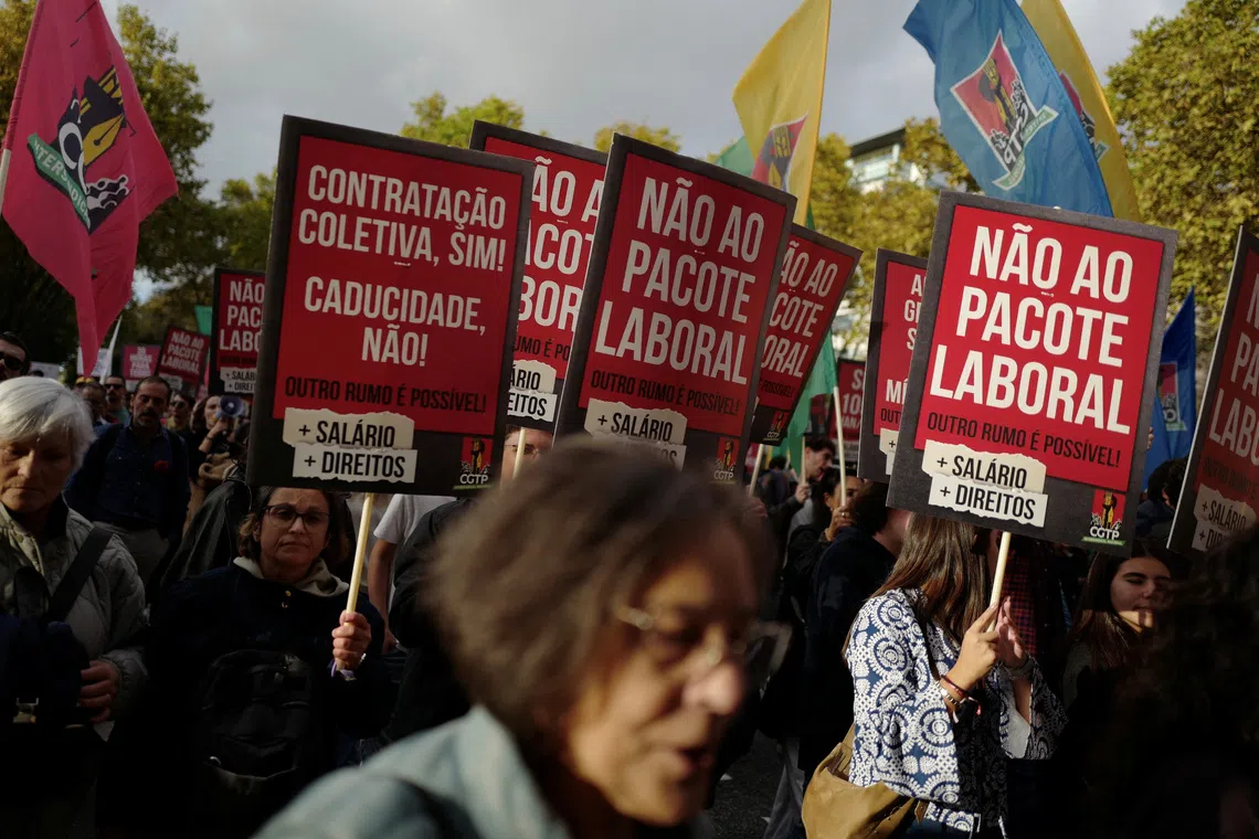 People hold placards during a demonstration held by the General Confederation of the Portuguese Workers (CGTP) demanding better wages and working conditions, in Lisbon, Portugal, November 8, 2025. REUTERS/Pedro Nunes