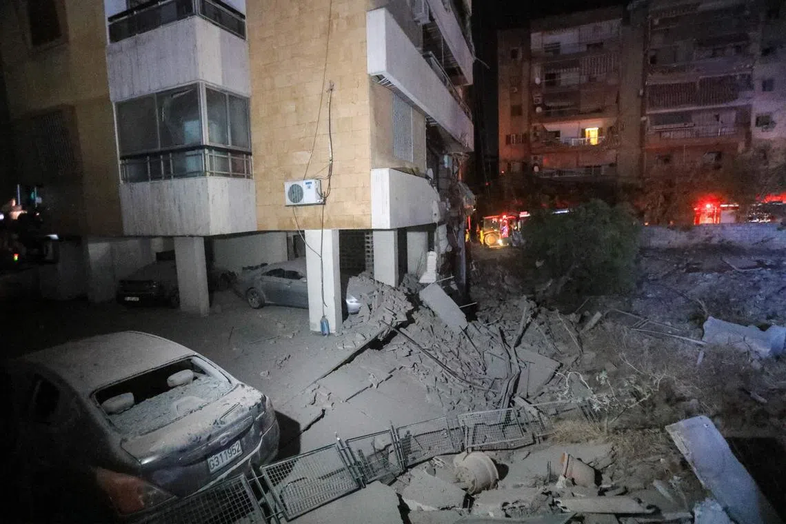 Damaged cars and buildings following an Israeli air strike in Beirut's southern suburbs on Sept 27.