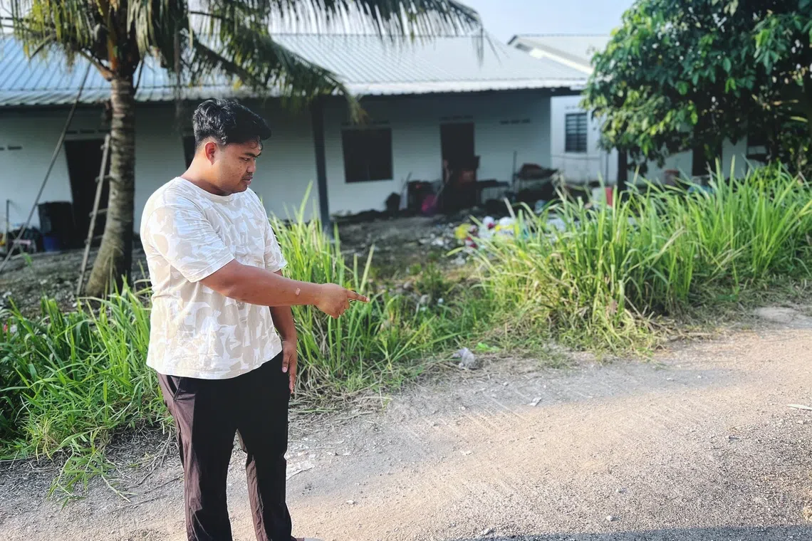 Rafi Mohamad Noor showing the trails on a gravel road near his home believed to be from trailers used for the illegal dumping of construction waste from Singapore.