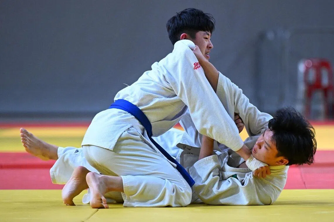 Phun Kai Xiang (top) and Elvyn Ee of Raffles Institution in action during the B Division boys' under-60kg final on April 15.