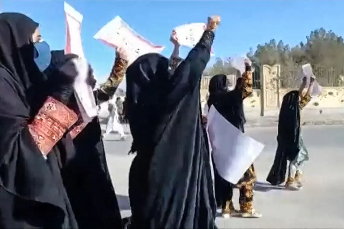 This image grab from a UGC video posted on Nov 25, 2022, reportedly shows women marching with anti-regime placards in the city of Zahedan, in Iran's Sistan-Baluchistan province. 