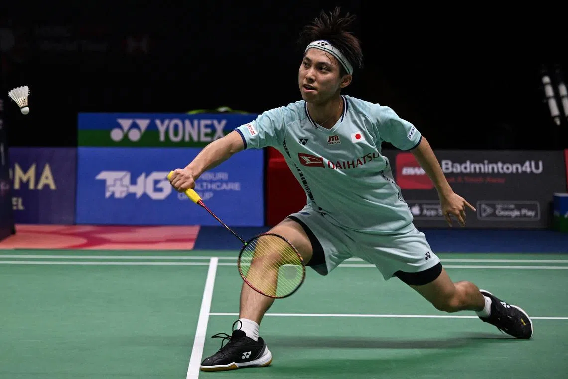 Japan's Kodai Naraoka hits a return against China's Li Shifeng during their men's singles semi-final match at the 2022 Thailand Open badminton tournament in Bangkok on May 21, 2022. (Photo by Lillian SUWANRUMPHA / AFP)