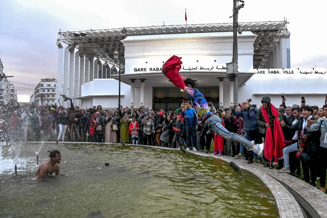 A fan of the Morocco national football team jumping into a fountain during celebrations outside the capital Rabat's Central Railway Station on Dec 1 after Morocco qualified to the round of 16 at the World Cup.