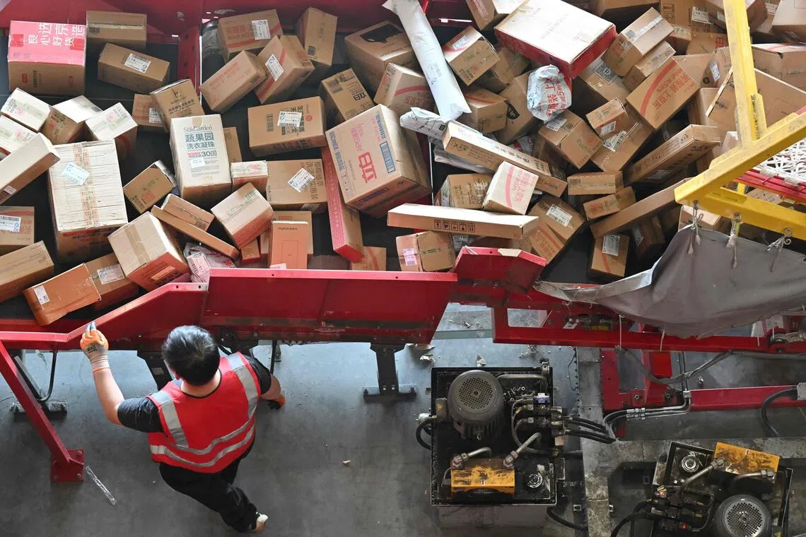 A worker sorts packages at JD's warehouse during the double 11 festival or Singles's Day, China's massive annual shopping event in Beijing on November 11, 2025. (Photo by Adek BERRY / AFP)