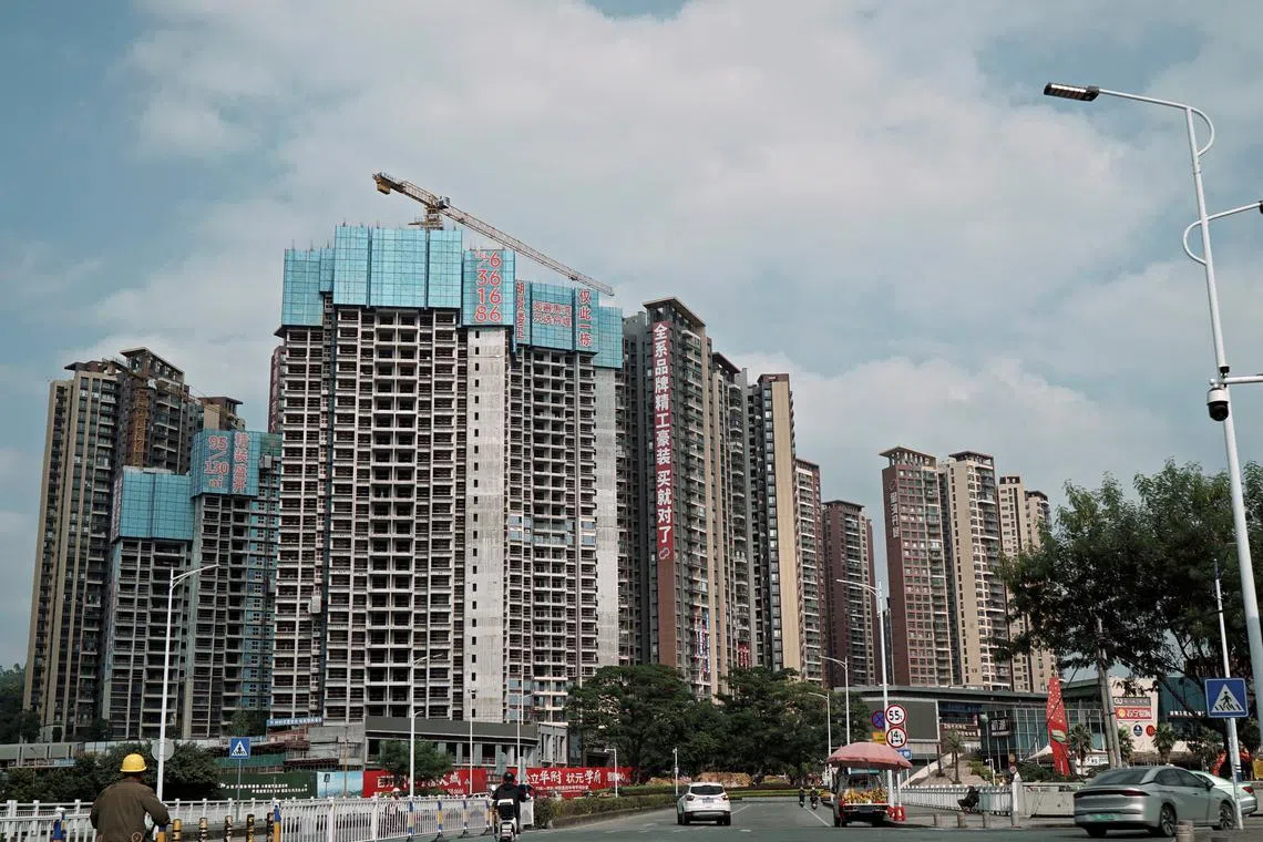 FILE PHOTO: Sale signs adorn residential buildings under construction in Huizhou, Guangdong province, China October 10, 2024. Picture taken through a windshield. REUTERS/Nicoco Chan/File Photo