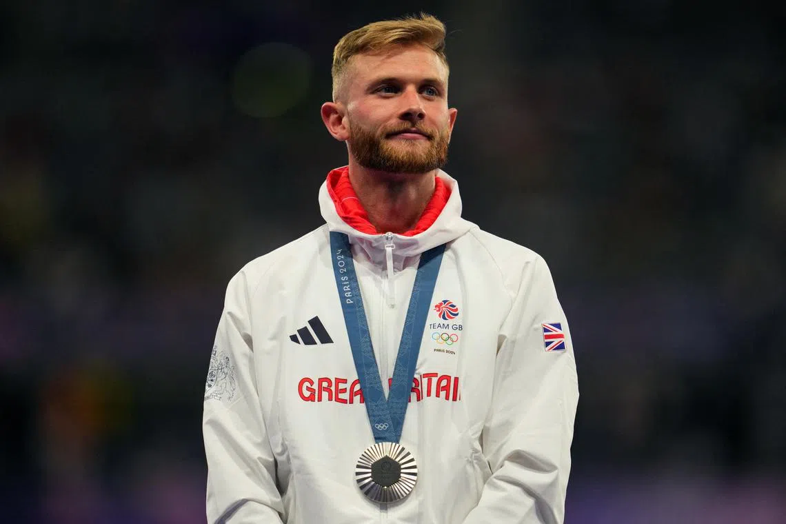 Paris 2024 Olympics - Athletics - Men's 1500m Victory Ceremony - Stade de France, Saint-Denis, France - August 06, 2024. Silver medaliist Josh Kerr of Britain celebrates with his medal on the podium REUTERS/Aleksandra Szmigiel/File Photo