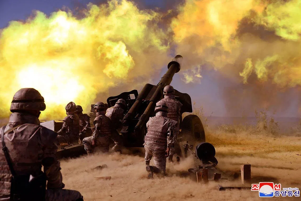 North Korean soldiers fire an artillery piece at an undisclosed location in North Korea. 