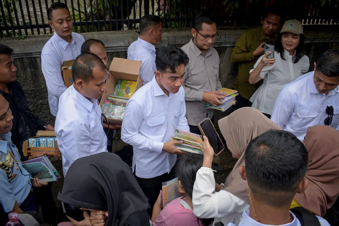 Indonesian vice-president Gibran Rakabuming Raka (centre) distributing food and stationery items in Bandung, Indonesia, in December 2024.