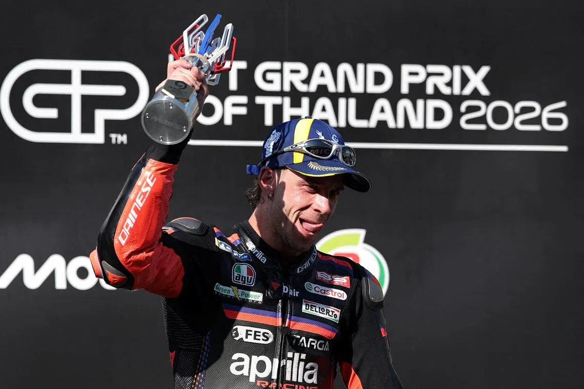 MotoGP - Thailand Grand Prix - Chang International Circuit, Buriram, Thailand - March 1, 2026 Aprilia Racing's Marco Bezzecchi celebrates winning the MotoGP race on the podium with the trophy REUTERS/Chalinee Thirasupa