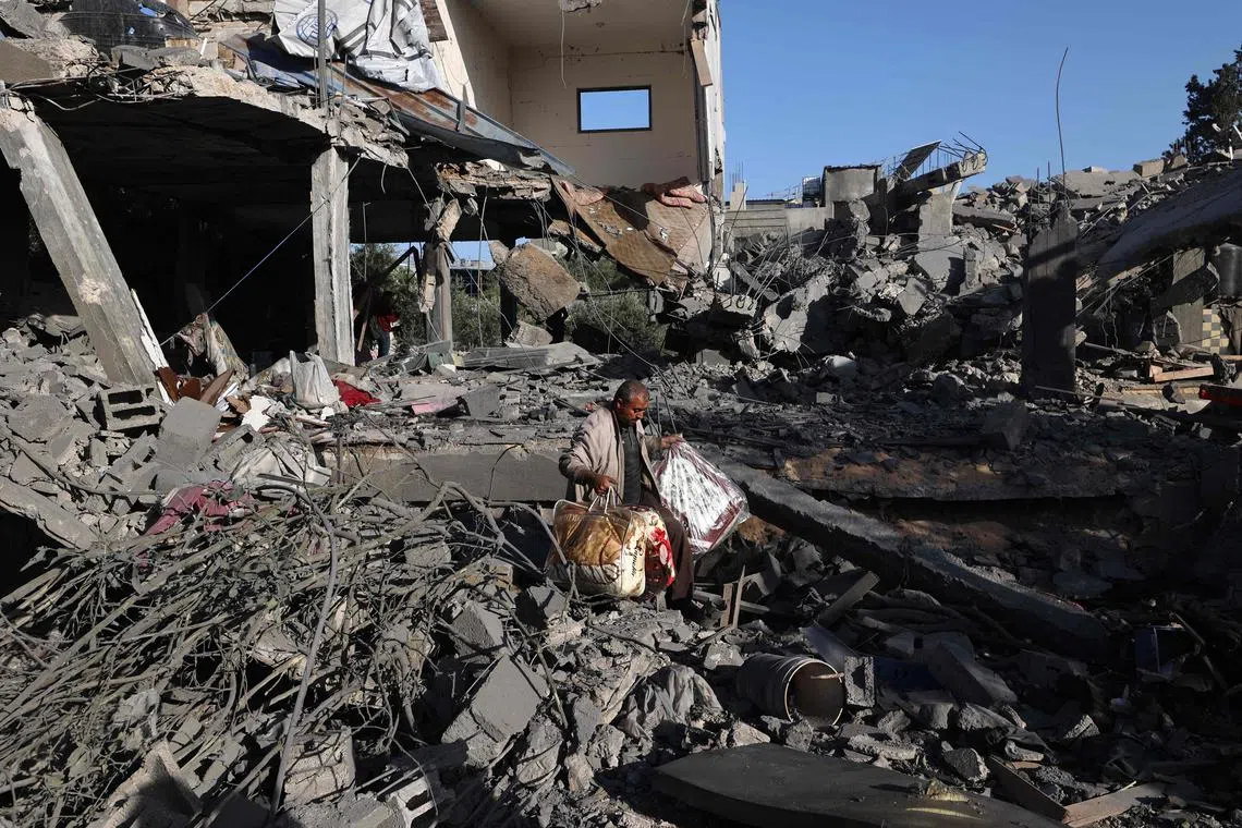 A Palestinian man carries items he salvaged from a house targeted in an Israeli strike at the Nuseirat camp for refugees in the central Gaza Strip, on May 24.