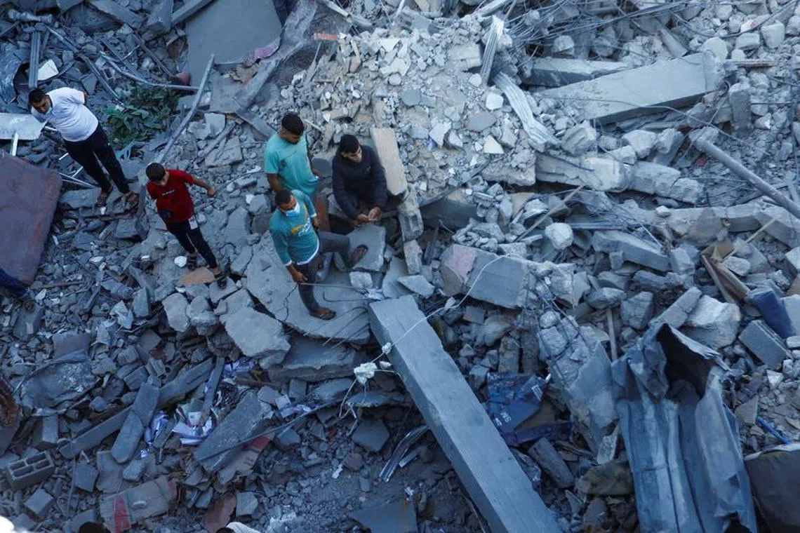 Palestinians search for casualties under the rubble in the aftermath of Israeli strikes amid the ongoing conflict between Israel and the Palestinian Islamist group Hamas, in Khan Younis in the southern Gaza Strip October 13, 2023. REUTERS/Ibraheem Abu Mustafa/File Photo