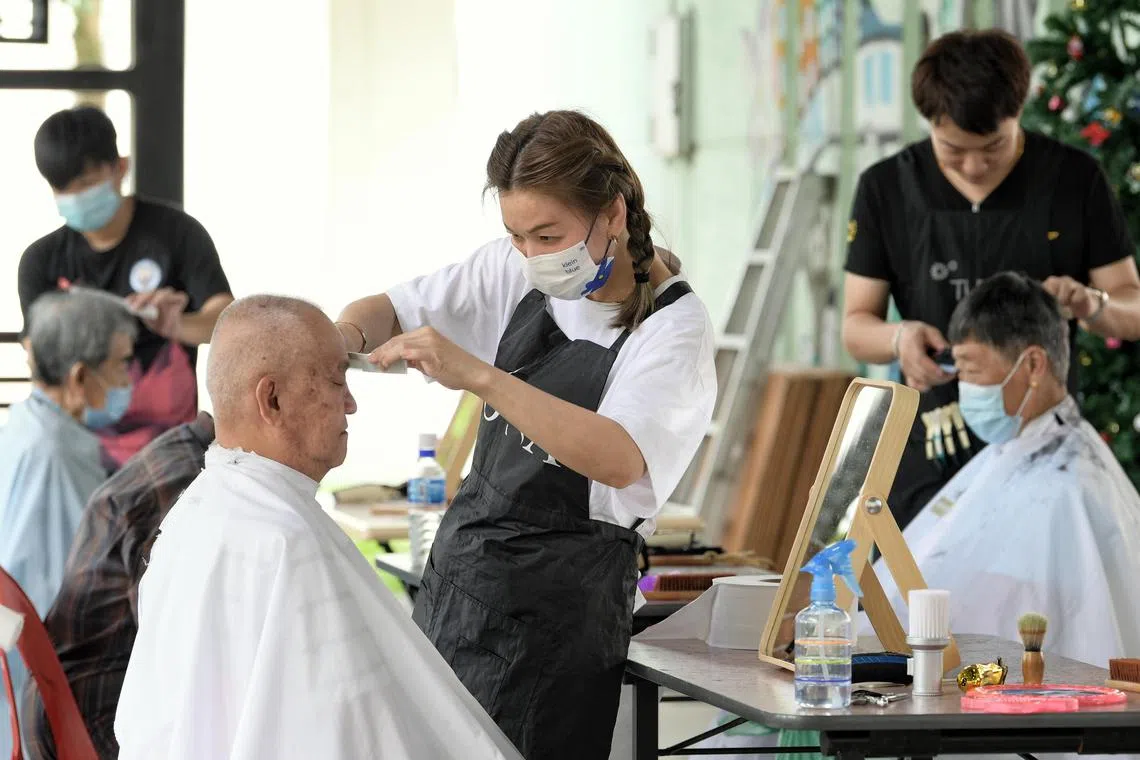 Hairtstylist Loh Mei Chien, 40, giving resident Cheong Chong Fatt, 70, a haircut. For elderly residents in Ubi, the third Friday of every month is when they can get free haircuts by volunteer hairdressers. The programme, which has been in place since 2017, sees about 80 elderly residents turn up.