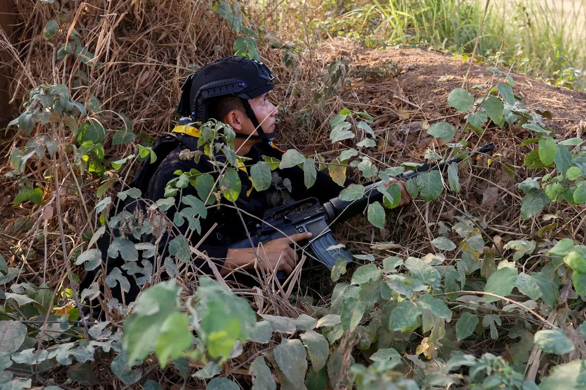 A Thai soldier takes cover near the 2nd Thailand-Myanmar Friendship Bridge during fighting on the Myanmar side between the Karen National Liberation Army (KNLA) and Myanmar's troops, which continues near the Thailand-Myanmar border, in Mae Sot, Tak Province,  Thailand, April 20, 2024. REUTERS/Soe Zeya Tun
