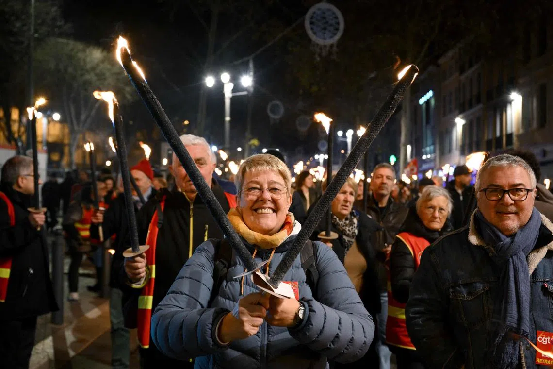 Protesters taking part in a torch-lit march called by the CGT workers' union to protest the French government's pensions reform plan, on the Canebiere in Marseille, south-eastern France, on Jan  17.