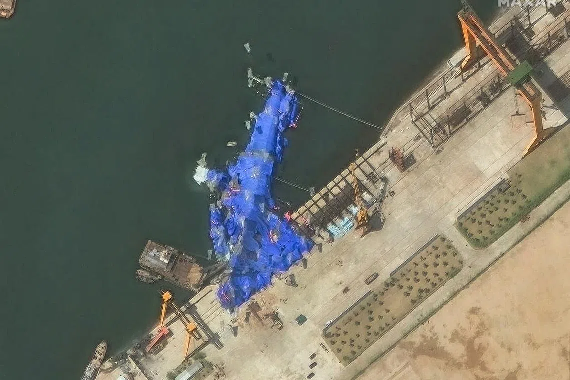 A satellite image released on May 23 showing the crippled 5,000-tonne warship covered with a blue tarpaulin after a failed launch.