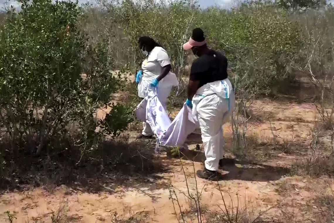 Detectives carry a body bag with exhumed remains of one of the suspected victims of a religious cult buried in shallow graves in Kwa Binzaro village, located on the outskirts of Malindi, in Kilifi County, Kenya, August 21, 2025. REUTERS/Dicksy O'Obiero