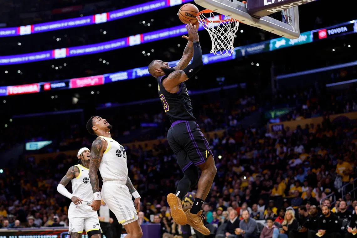 LeBron James of the Los Angeles Lakers scores a basket against John Collins of the Utah Jazz during the first half at Crypto.com Arena.