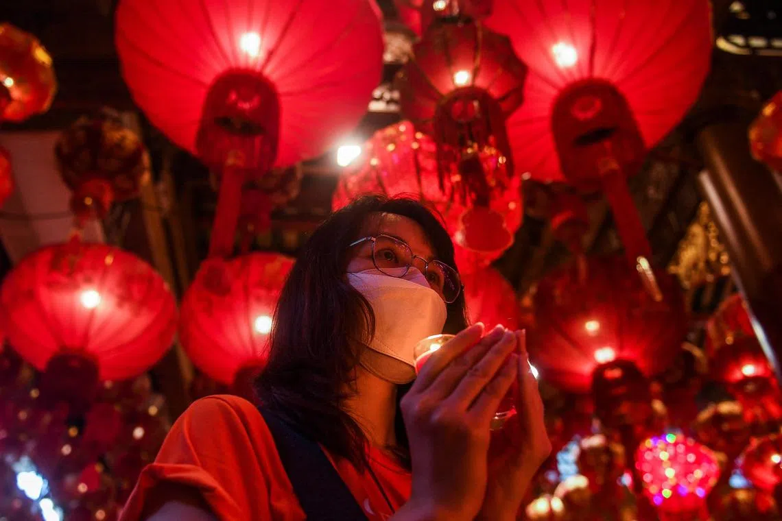 A woman makes offerings on Lunar New Year's Eve at a temple in China Town in Bangkok, on Jan 21, 2023.
