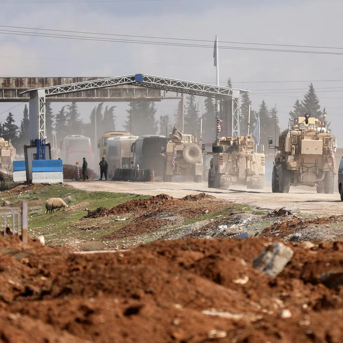 U.S. military vehicles escort buses transporting Islamic State detainees from Syria to Iraq, according to a security source from the Syrian Democratic Forces, in Qamishli, Syria, February 8, 2026. REUTERS/Orhan Qereman