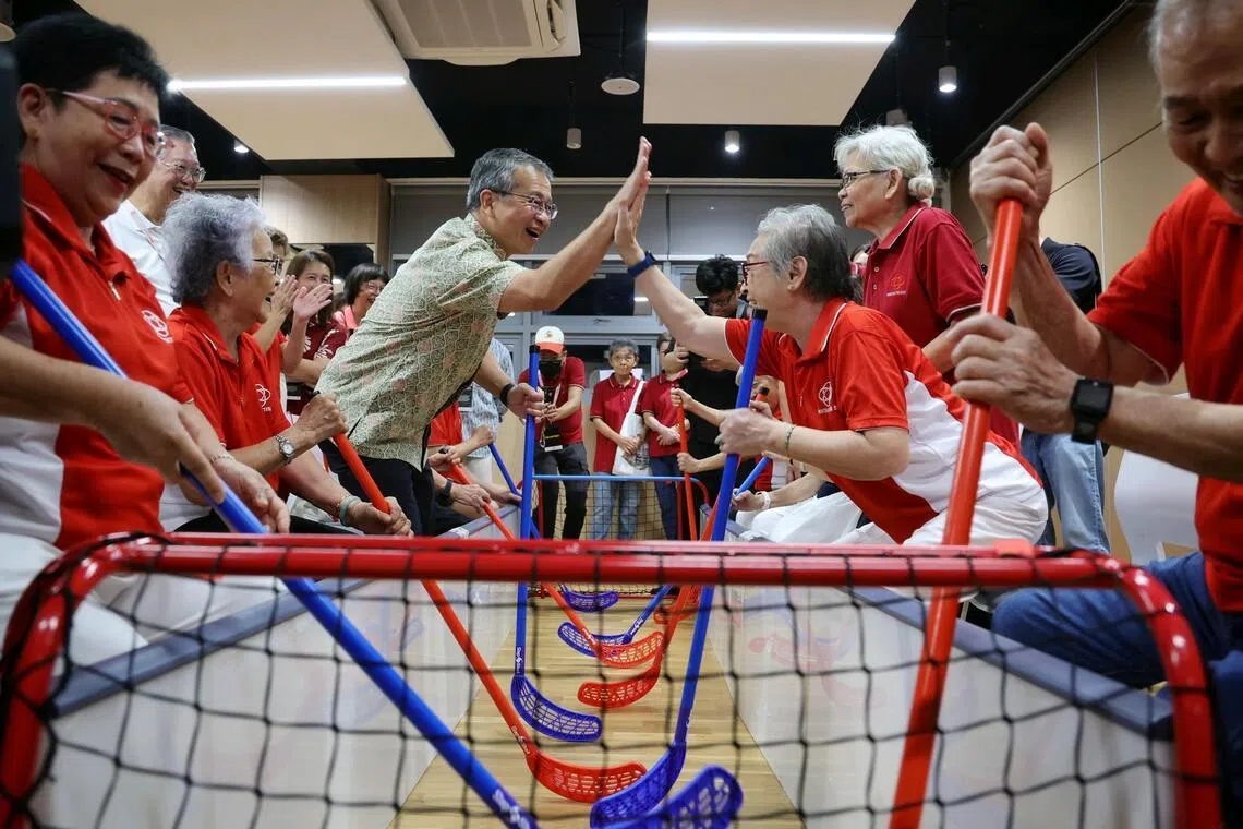 Law Minister Edwin Tong high-fiving Mountbatten resident Madam Tan How Khinn, 80, after their team scored a goal during a modified game of floorball with seniors at the launch of the new Mountbatten Community Club on April 4, 2026. ST PHOTO: KEVIN LIM zykaki04