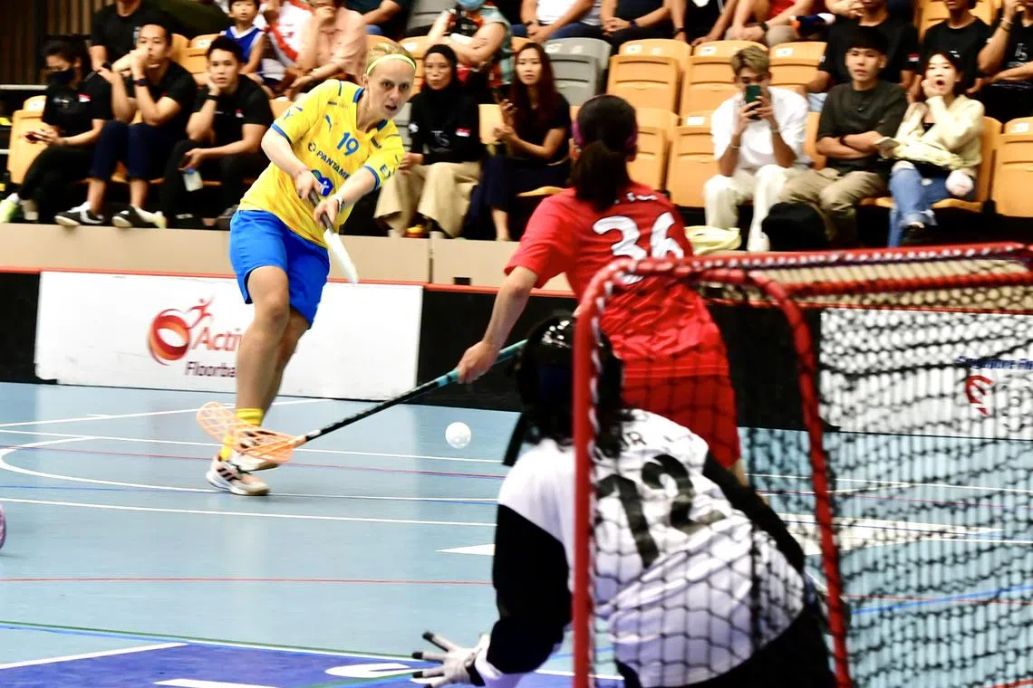 Swedish floorballer Elin Roos (in yellow) attempts a shot during Sweden's friendly against Singapore on May 28, 2023.