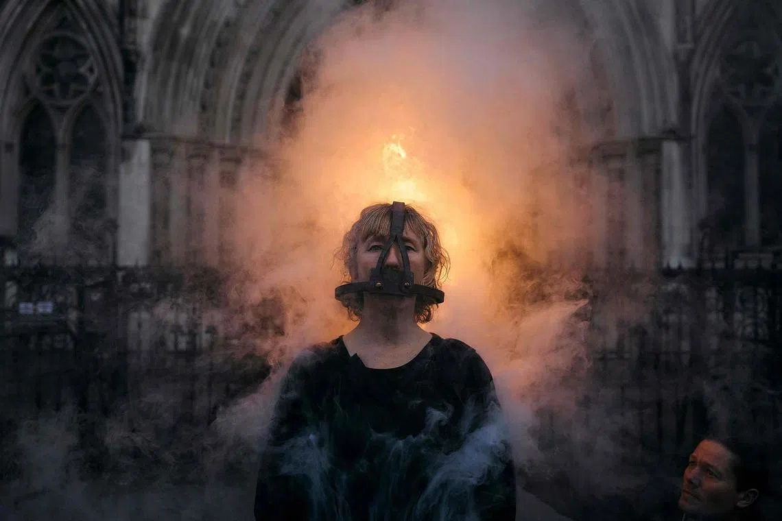 TOPSHOT - An activist from Ocean Rebellion stands as she wears a Scold’s Bridles—medieval torture device, during an action outside the Royal High Court of Justice, in central London, on January 29, 2025. (Photo by BENJAMIN CREMEL / AFP)