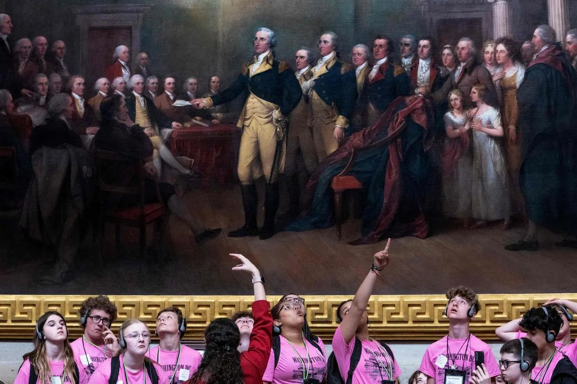 Students standing next to a John Trumbull painting of General George Washington resigning as Commander-in-Chief of the Continental Army in 1783, during their visit to the Capitol in Washington, DC, on May 16, 2024. 