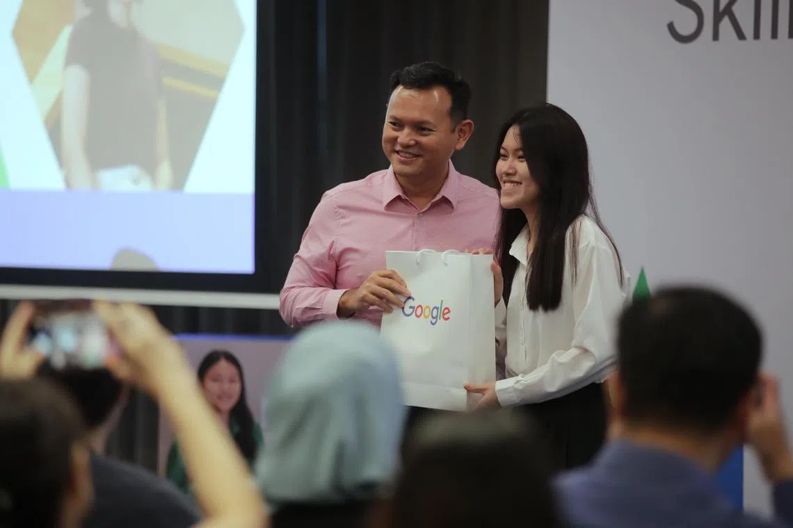 Senior Minister of State for Manpower Zaqy Mohamad presenting a token of appreciation to Ms Ngui Jia Xuan, a graduate of the Google Career Certificates programme.