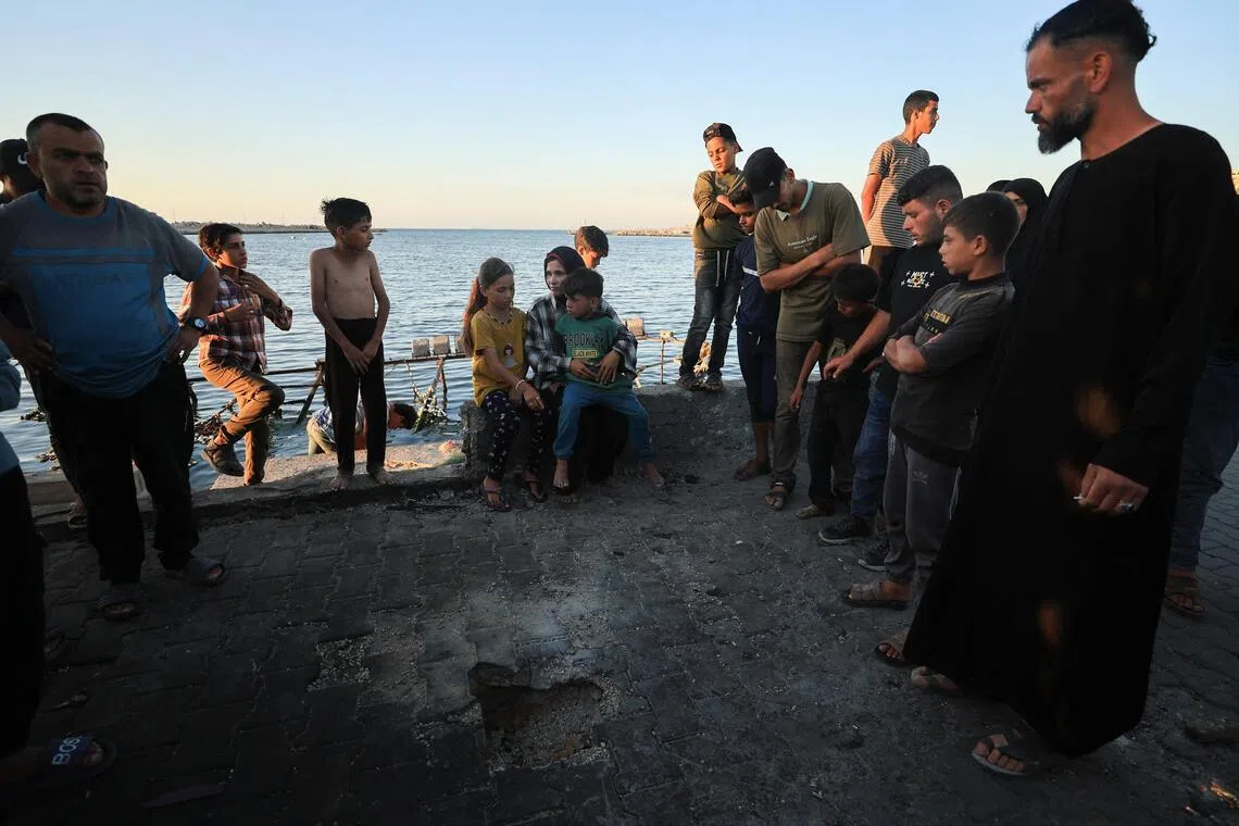 Palestinians gathering at the site of a May 31 Israeli air strike on a cafe in Gaza City's seaport.