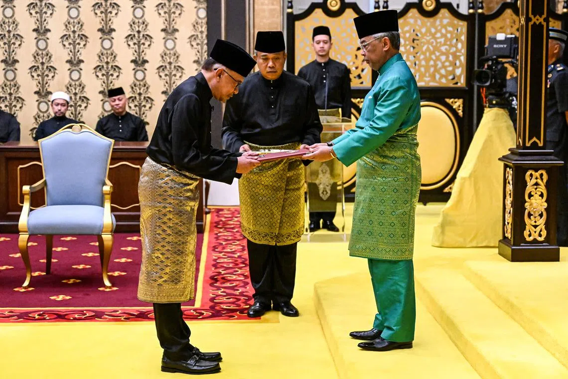 Malaysia's King Sultan Abdullah Sultan Ahmad Shah (R) and Malaysia's newly appointed Prime Minister Anwar Ibrahim (L) take part in the swearing-in ceremony at the Istana Negara (National Palace) in Kuala Lumpur, Malaysia, Nov 24, 2022. 