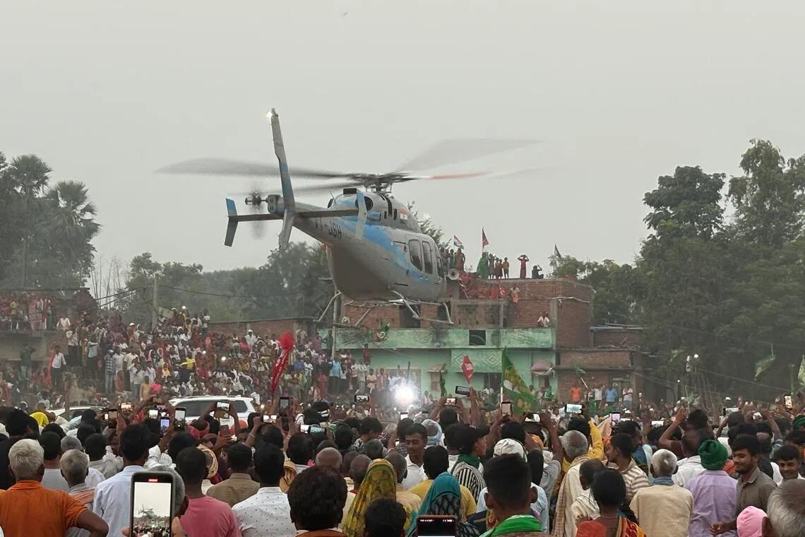 A crowd watching as opposition leader Tejashwi Yadav of the Rashtriya Janata Dal leaves a Bihar rally in a helicopter on Nov 3. 