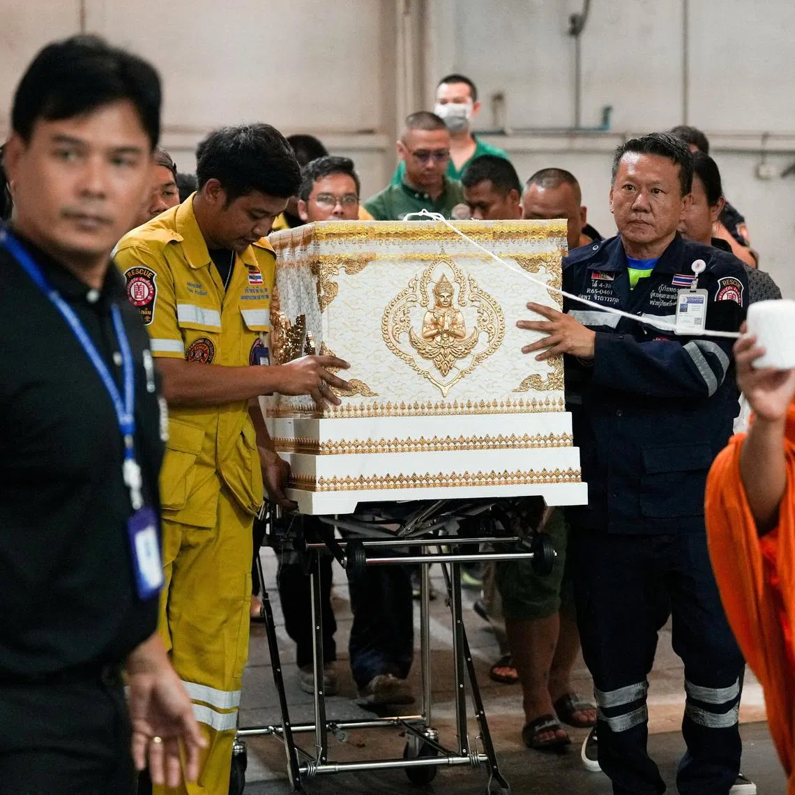 Emergency services members move a coffin with the body of a victim at the Police Hospital morgue, following a deadly fire at a pub in Bangkok, Thailand, July 13, 2026. REUTERS/Arnun Chonmahatrakool