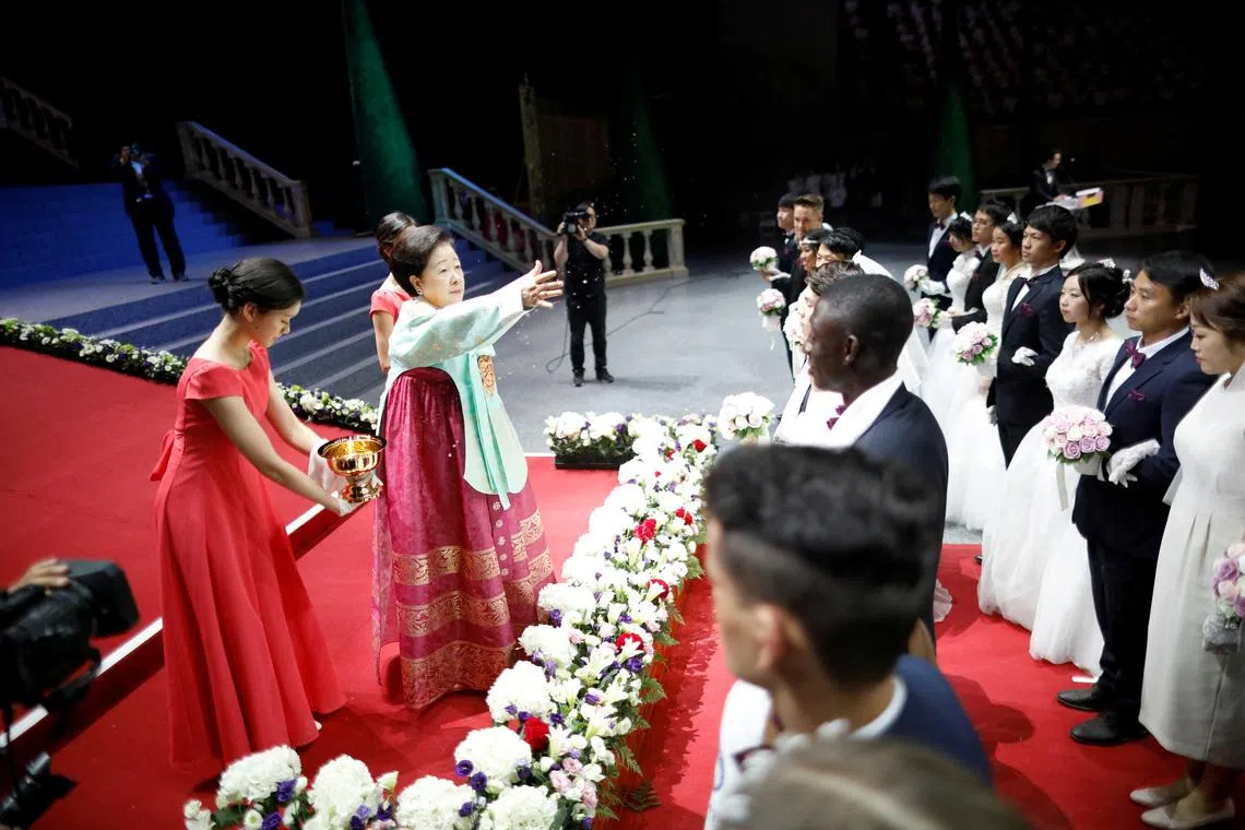 FILE PHOTO: Han Hak-ja, widow of Evangelist Reverend Moon Sun-myung, sprays holy water to bless couples during a mass wedding ceremony of the Unification Church at Cheongshim Peace World Centre in Gapyeong, South Korea, August 27, 2018.   REUTERS/Kim Hong-Ji/File Photo