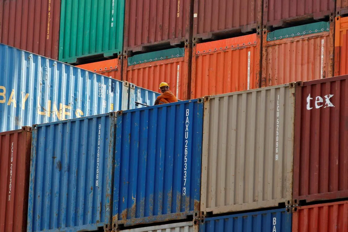 FILE PHOTO: A worker sits on a ship carrying containers at Mundra Port in the western Indian state of Gujarat April 1, 2014. REUTERS/Amit Dave/File Photo