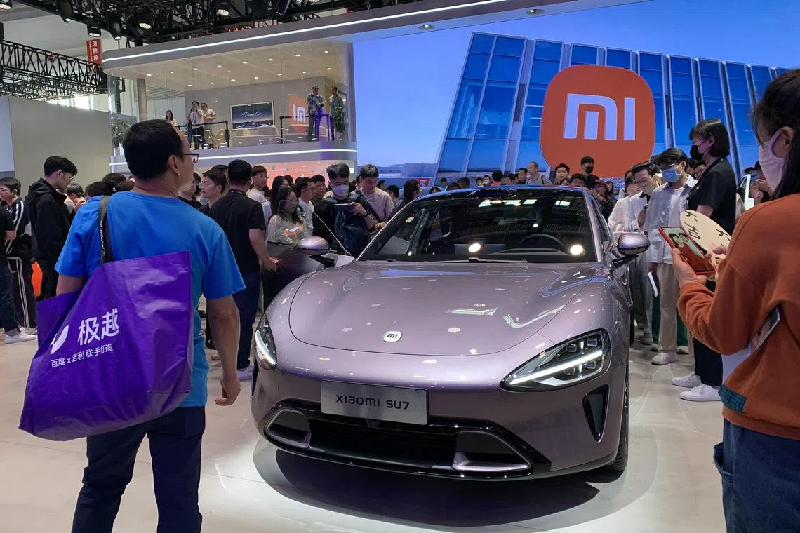 Visitors viewing the Xiaomi SU7 up close at the Beijing International Automotive Exhibition on May 2, 2024.