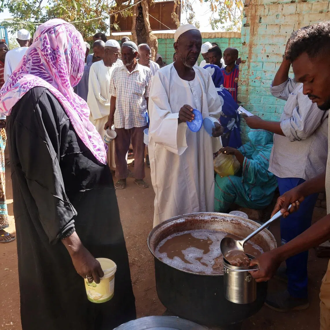 FILE PHOTO: Volunteers distribute food to residents and displaced people in Omdurman, Sudan, March 8, 2024. Nearly five million people in the country are close to famine as Sudan's civil war passes the one-year mark. REUTERS/El Tayeb Siddig/File Photo