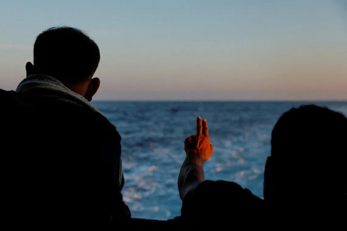 FILE PHOTO: A migrant gestures on the Geo Barents migrant rescue ship, operated by Medecins Sans Frontieres (Doctors Without Borders), as it makes its way to Italy after the rescue of 61 migrants on a wooden boat in international waters off the coast of Libya in the central Mediterranean Sea, September 30, 2023. REUTERS/Darrin Zammit Lupi/File Photo