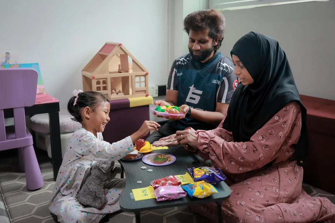 Madam Nasrin Shah Beevi and her husband, Mr Nizamudheen Ishak role-playing as a cashier, selling food items to their six-year-old daughter, Nur Zahirah Nizamudheen.