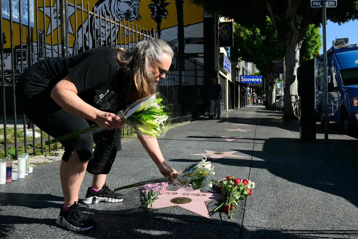 A woman places flowers at Rob Reiner’s Star on the Hollywood Walk of Fame in Los Angeles.