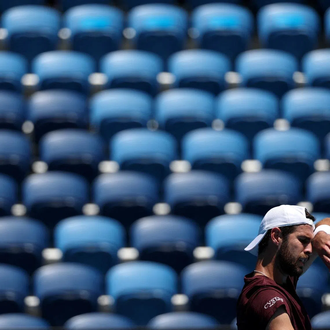 Tennis - Australian Open - Melbourne Park, Melbourne, Australia - January 24, 2026 Russia's Karen Khachanov wipes his brow in front of empty seats during his third round match against Italy's Luciano Darderi REUTERS/Hollie Adams