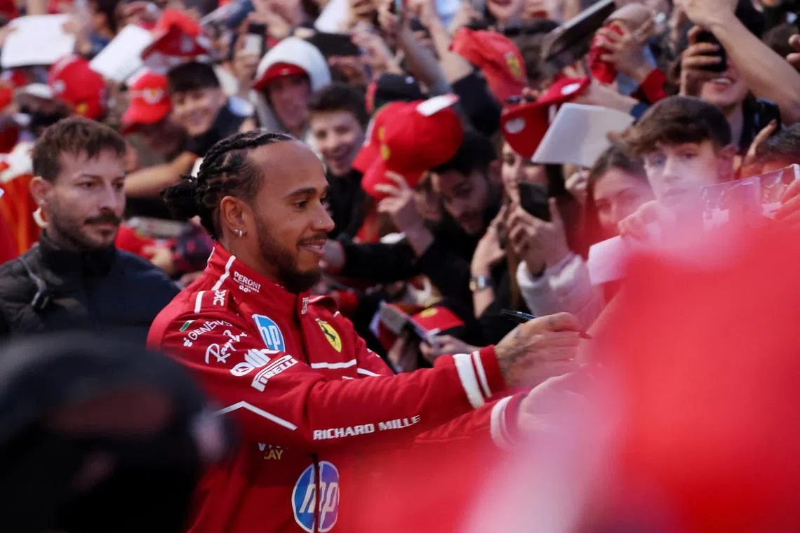 FILE PHOTO: Formula One F1 - Ferrari presents new driving pairing Lewis Hamilton and Charles Leclerc to the public - Milan, Italy - March 6, 2025 Ferrari's Lewis Hamilton signs his autograph for fans during the presentation REUTERS/Claudia Greco/File Photo