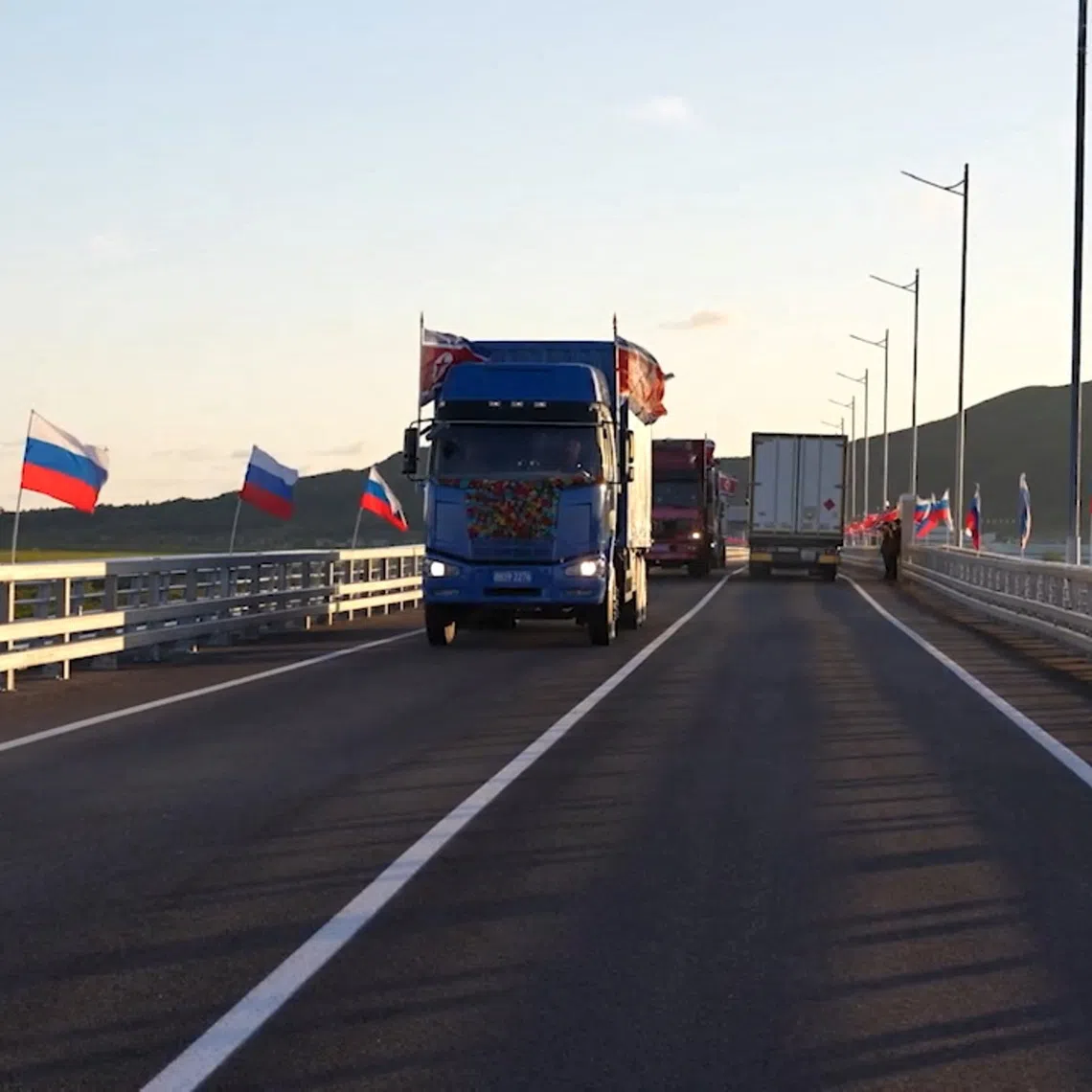 Trucks drive along a road during a ceremony opening the first road bridge between Russia and North Korea across the Tumen River, locally known as Tumannaya, on the border with North Korea in the Primorsky region, Russia, September 7, 2026, in this still image taken from a video. Russian Government/Handout via REUTERS
