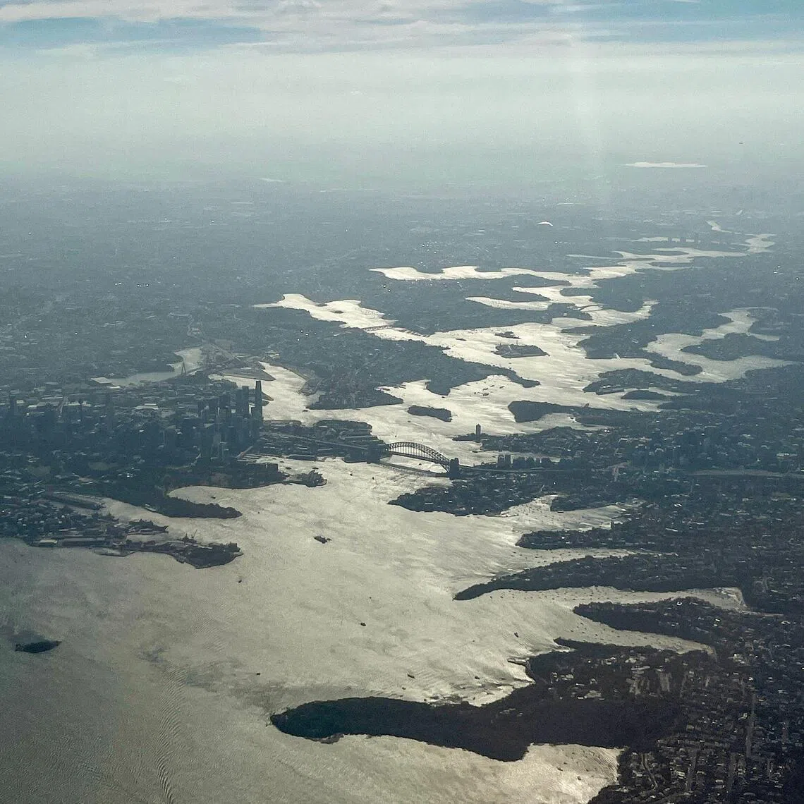 An aerial view of smoke from bushfires on the outskirts of Sydney hanging above Sydney Harbour on Dec 8, 2025.