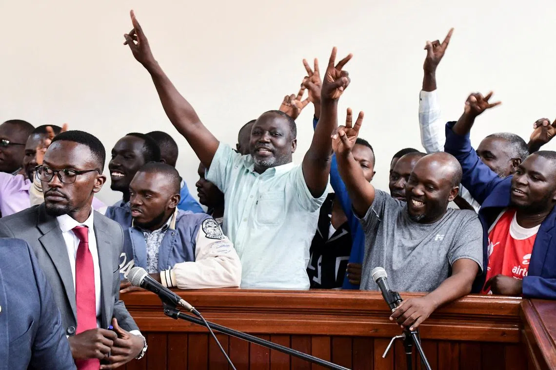 Ugandan opposition supporters gesture in the dock where they were charged with terrorism-related offences, after they were deported from neighbouring Kenya, where they had traveled to attend a training course in Kisumu, at the Nakawa Chief Magistrates court in Kampala, Uganda July 29, 2024. REUTERS/Abubaker Lubowa/File Photo