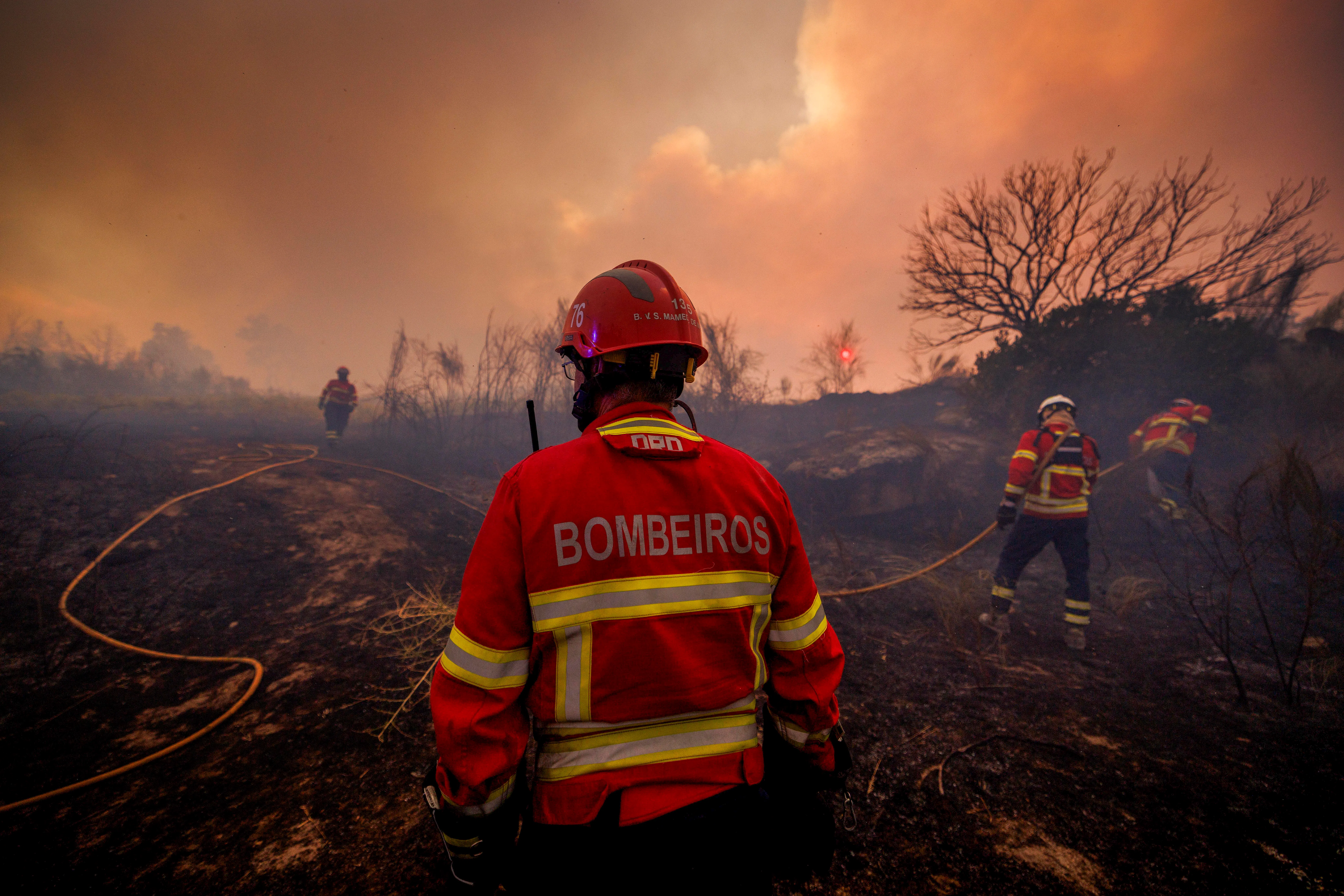Firefighters battling flames in Valpacos, Portugal, on July 30.