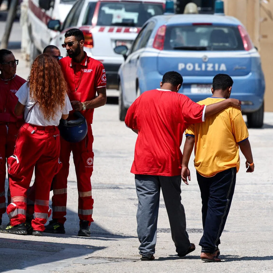 Members of the Italian Red Cross speak to each other outside the hotspot, a reception centre for migrants, in Lampedusa, Italy, on Aug 15, 2025.