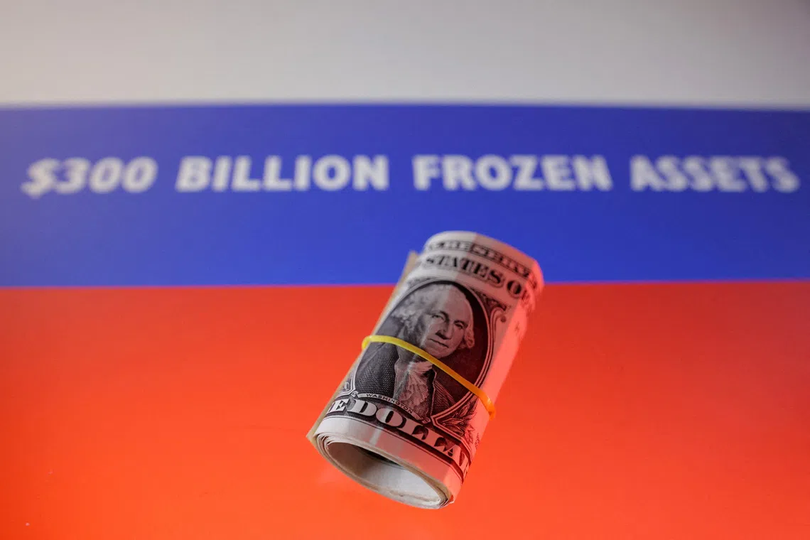 FILE PHOTO: U.S. dollar banknotes and Russian flag with words \"$300 billion frozen assets\" are seen in this illustration taken, February 21, 2025. REUTERS/Dado Ruvic/Illustration/File Photo