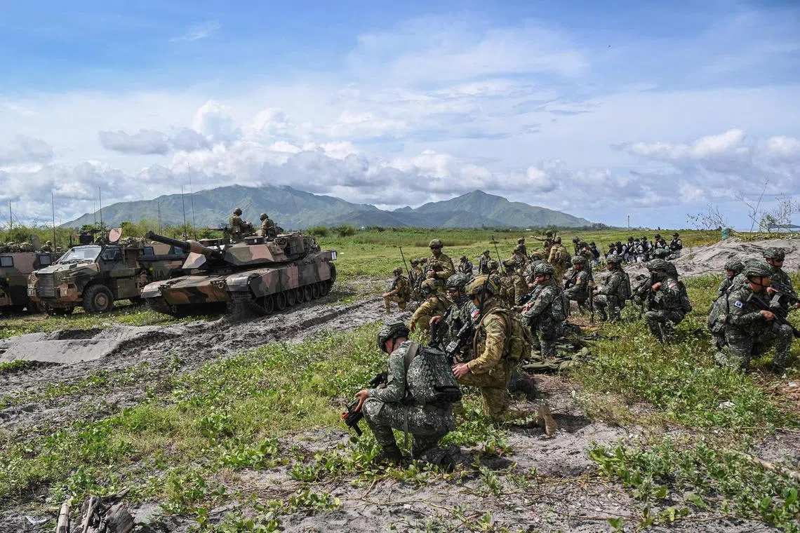 TOPSHOT - Australian and Philippine soldiers take position as an Australian A1 Abrams tank moves along a beach during a joint exercise at a naval base in San Antonio town, Zambales province on August 25, 2023. Australian and Filipino troops held exercises on August 25 near flashpoint South China Sea waters claimed by China, with Philippine President Ferdinand Marcos hailing them as an "extremely important" example of close cooperation. (Photo by Ted ALJIBE / AFP)